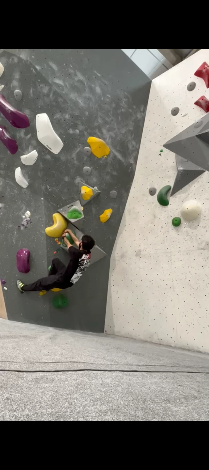Ali Zaman en train d'escalader un mur de bloc en salle d'escalade